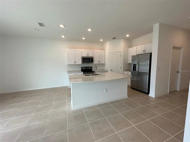 a kitchen with stainless steel appliances a refrigerator sink and microwave