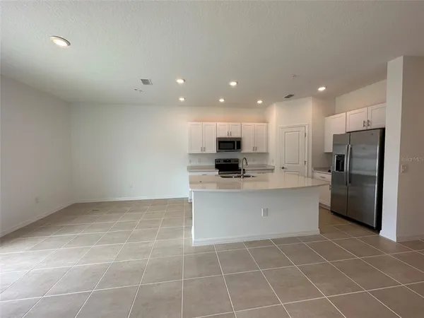 a view of kitchen with stainless steel appliances refrigerator sink and microwave