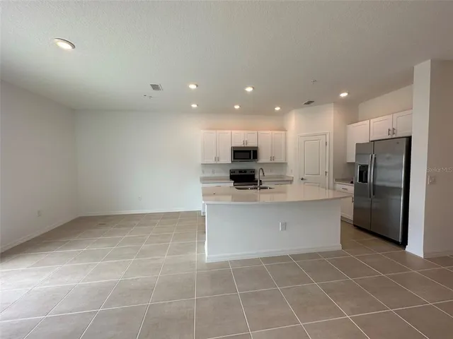 a view of kitchen with stainless steel appliances refrigerator sink and microwave