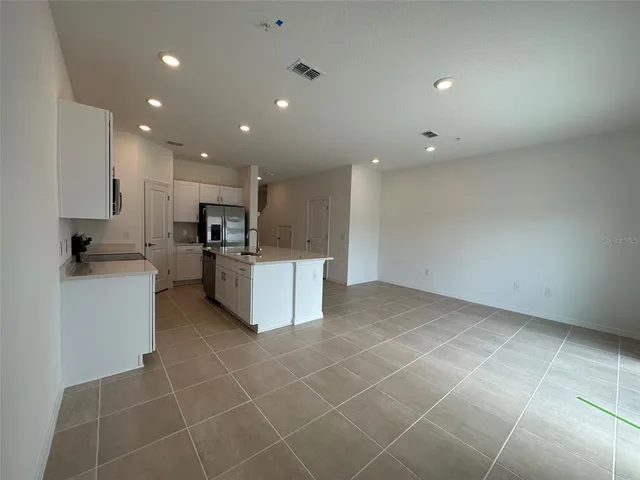 a kitchen with stainless steel appliances a sink a stove a refrigerator and cabinets