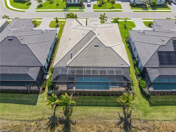 an aerial view of residential houses with outdoor space and ocean view
