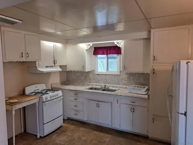 a kitchen with a sink stove and cabinets