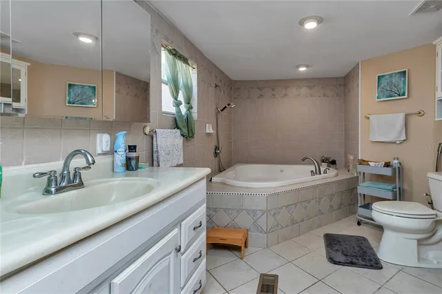 a kitchen with stainless steel appliances granite countertop a refrigerator a stove top oven a sink dishwasher and wooden cabinets with wooden floor