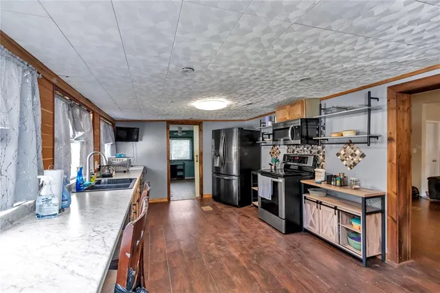 a kitchen with stainless steel appliances a refrigerator and a stove top oven