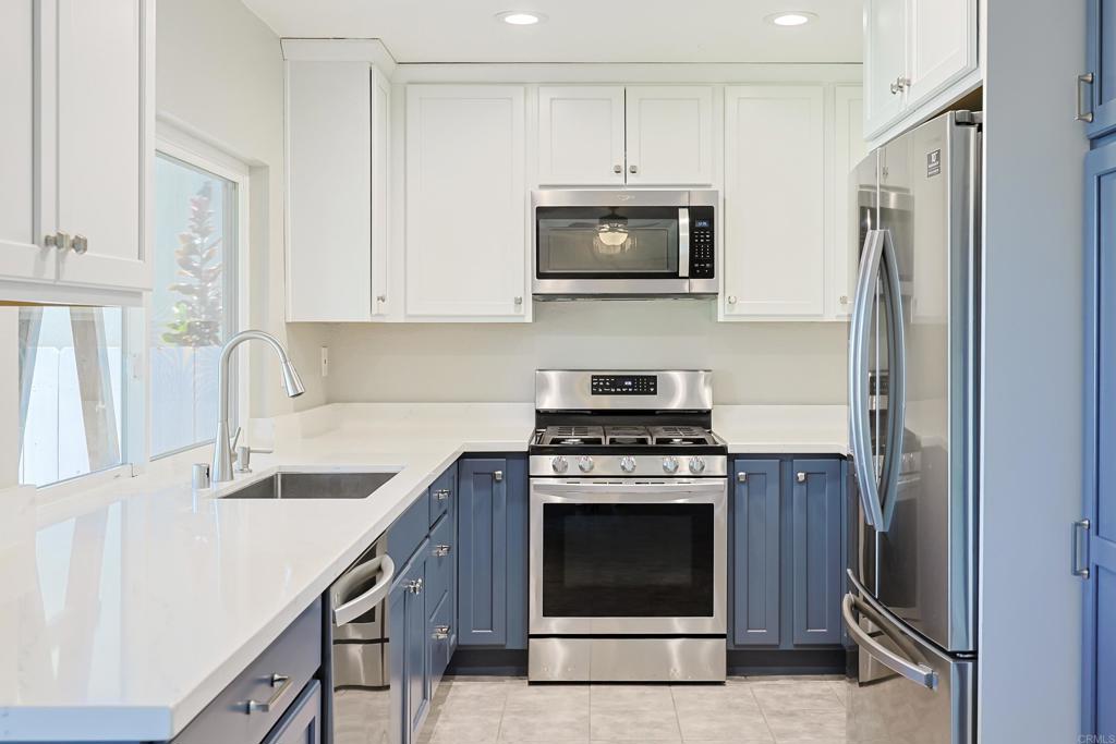 10225 Molino Road Santee, CA 92071 - Photo 15 of 53 a kitchen with white cabinets and stainless steel appliances