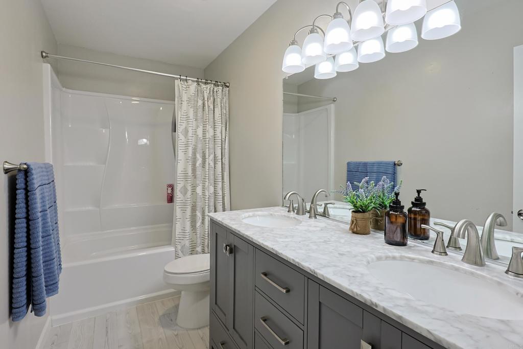 10225 Molino Road Santee, CA 92071 - Photo 31 of 53 a bathroom with a granite countertop sink a toilet and shower