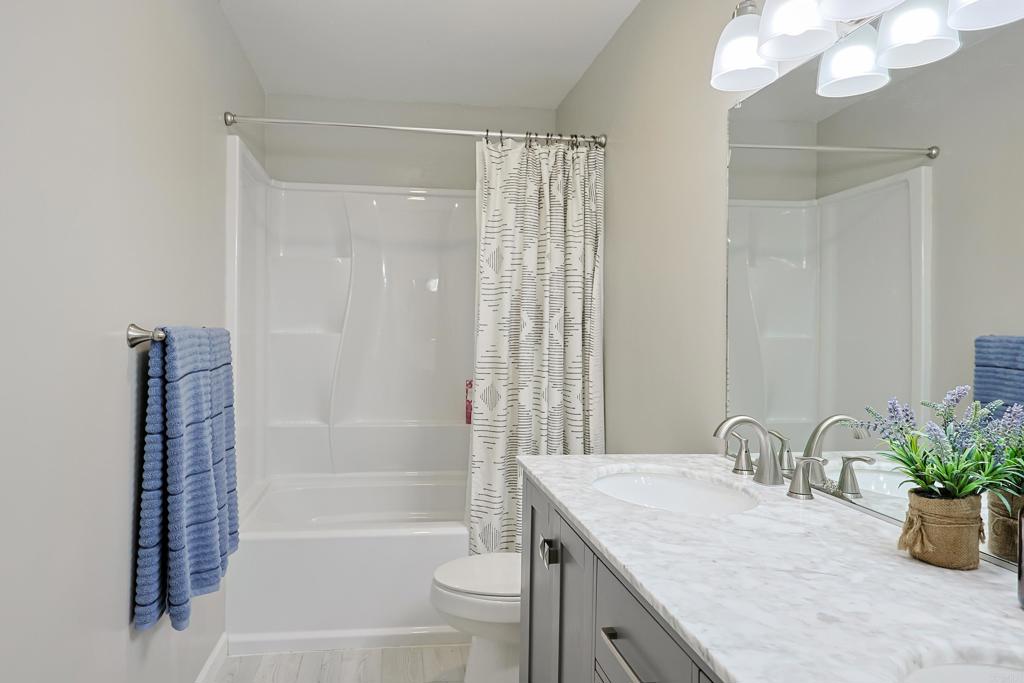 10225 Molino Road Santee, CA 92071 - Photo 32 of 53 a bathroom with a granite countertop sink a toilet and shower