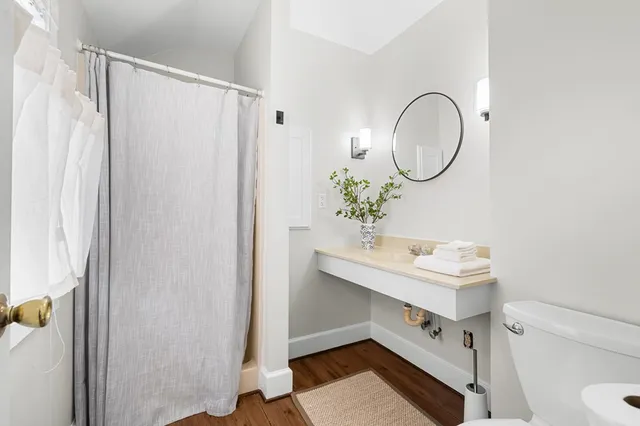 a bathroom with a sink a toilet and shower
