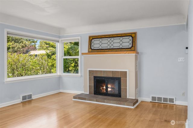 a view of an empty room with a fireplace and a window