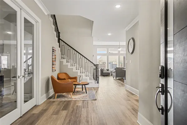 a view of a hallway with wooden floor and stairs