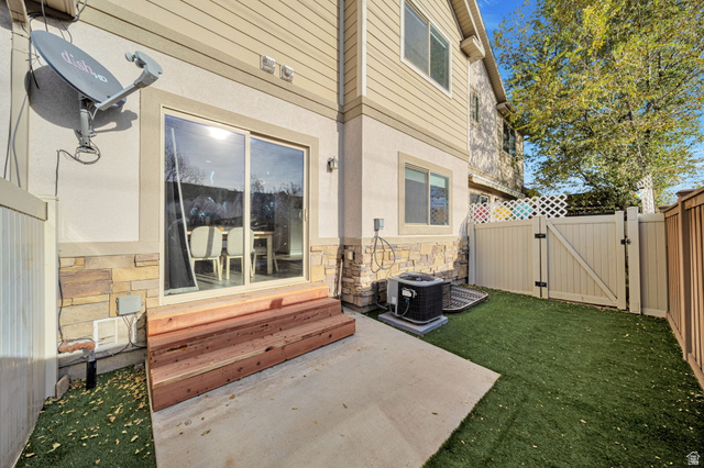11730 South Shadow Lane Draper, UT 84020 - Photo 23 of 24 View of exterior entry featuring a gate, a patio area, stone siding, and stucco siding