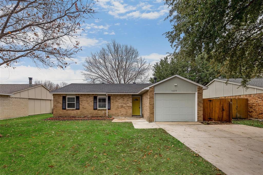 Ranch-style home featuring a garage and a front lawn