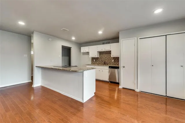 a kitchen with a refrigerator and white cabinets