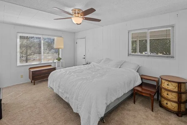 a large bed sitting in a bedroom next to a window