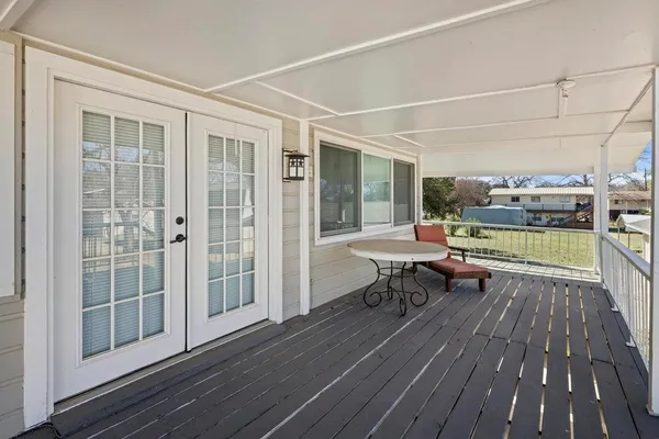 a view of a deck with table and chairs with wooden floor and fence