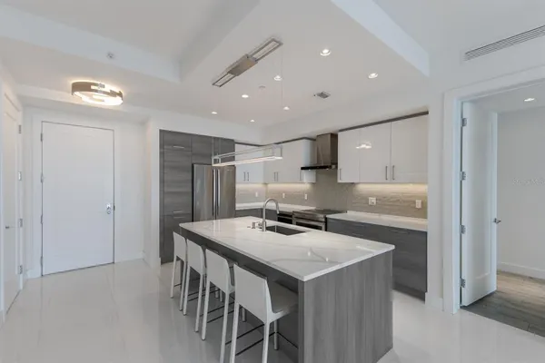 a kitchen with stainless steel appliances granite countertop a sink a stove and a refrigerator
