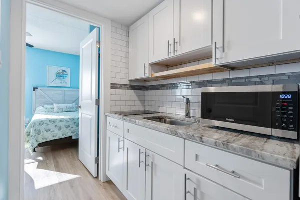 a kitchen with granite countertop a sink and cabinets