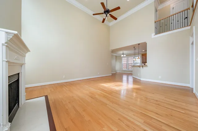a view of empty room with wooden floor and fireplace