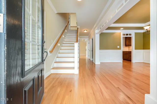 a view of a hallway with wooden floor and staircase