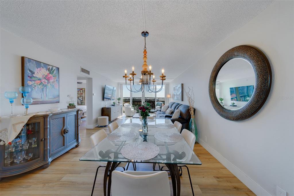 255 Dolphin Point, Unit 802 Clearwater Beach, FL 33767 - Photo 3 of 41 a view of a dining room with furniture and a chandelier