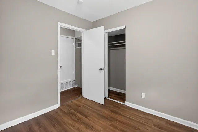 an empty room with wooden floor and entrance