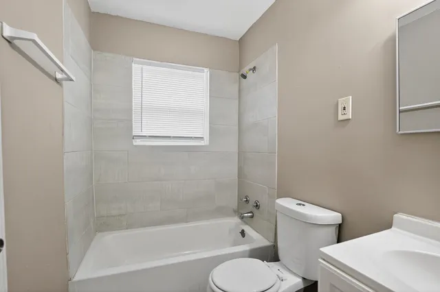 a white toilet sitting next to a bath tub