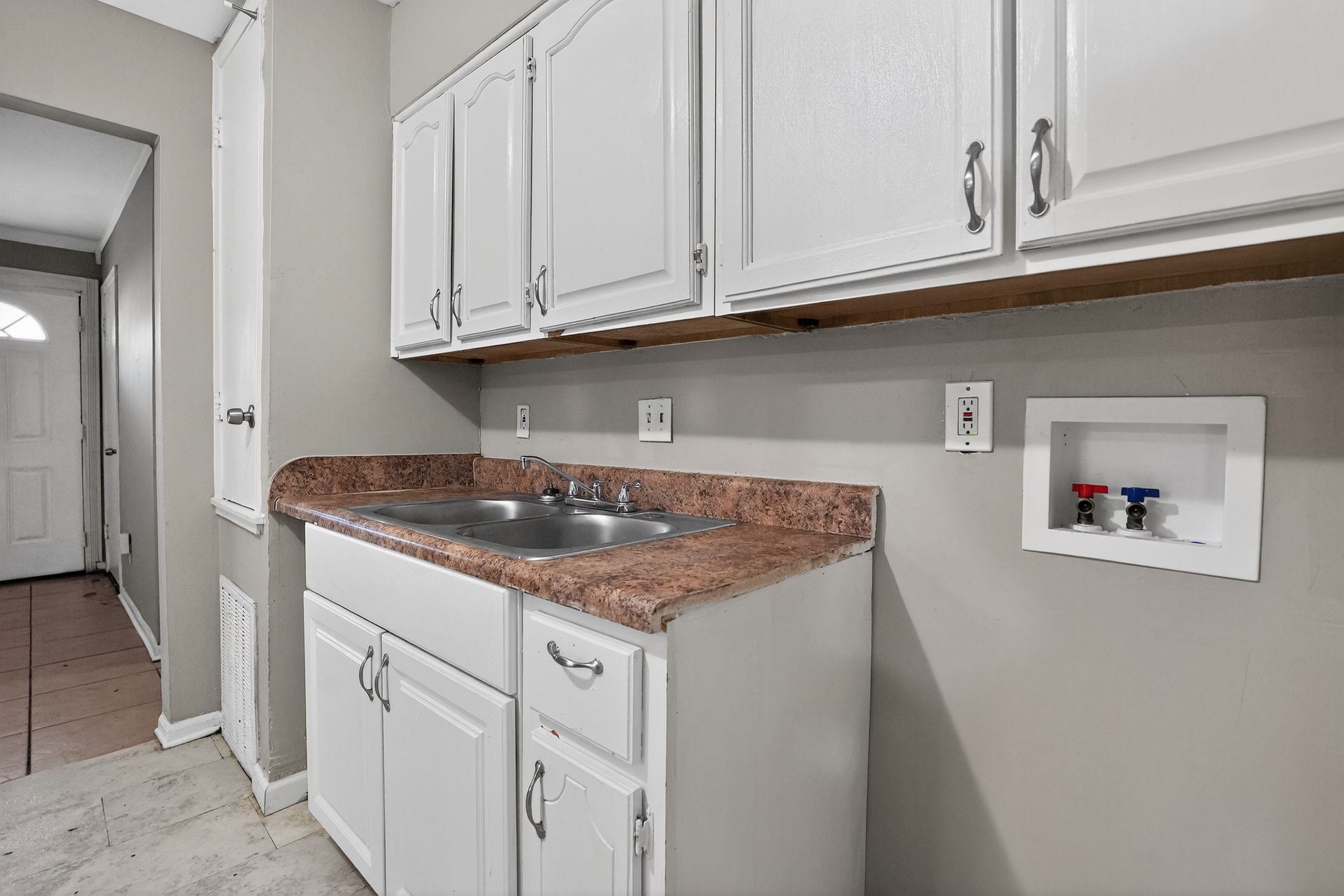 3981 Maynard Drive Memphis, TN 38109 - Photo 25 of 31 Laundry area with washer hookup, cabinet space, and light tile patterned flooring