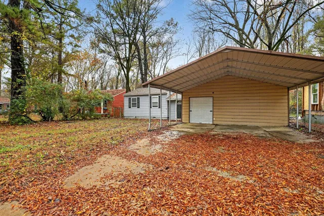 a backyard of a house with large trees and brick walls