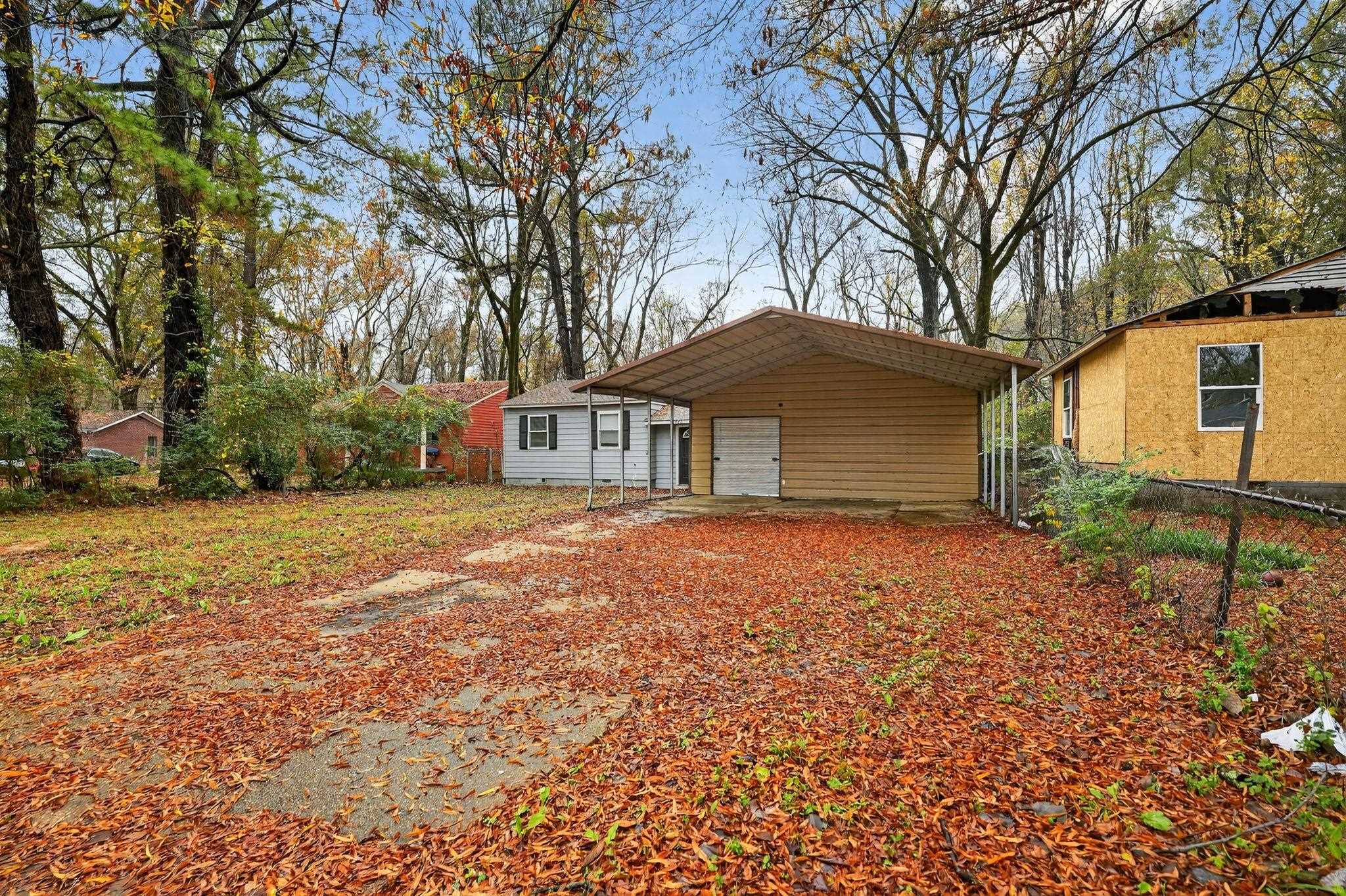 3981 Maynard Drive Memphis, TN 38109 - Photo 31 of 31 a backyard of a house with large trees and barbeque oven