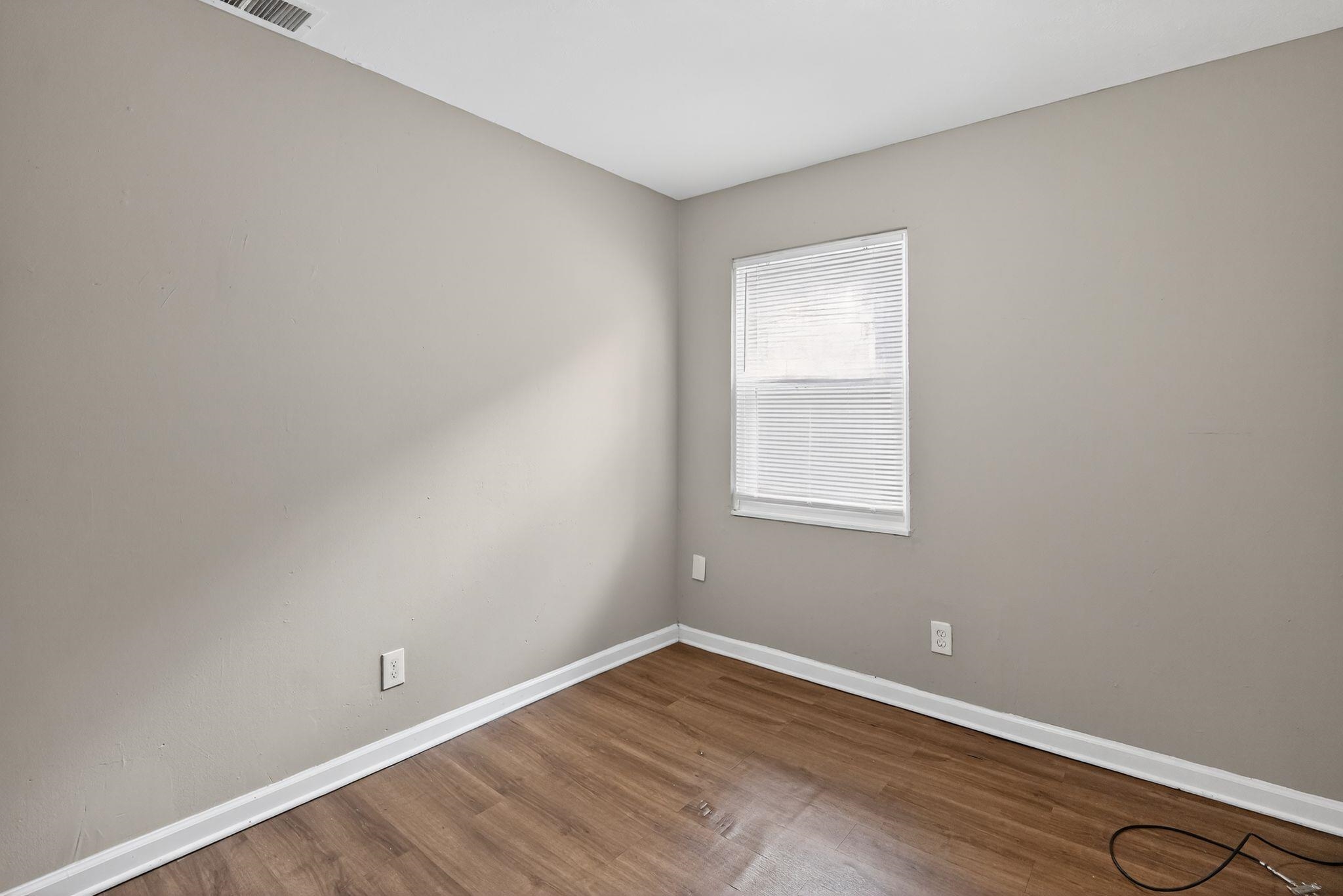 3981 Maynard Drive Memphis, TN 38109 - Photo 5 of 31 a view of an empty room with wooden floor and a window