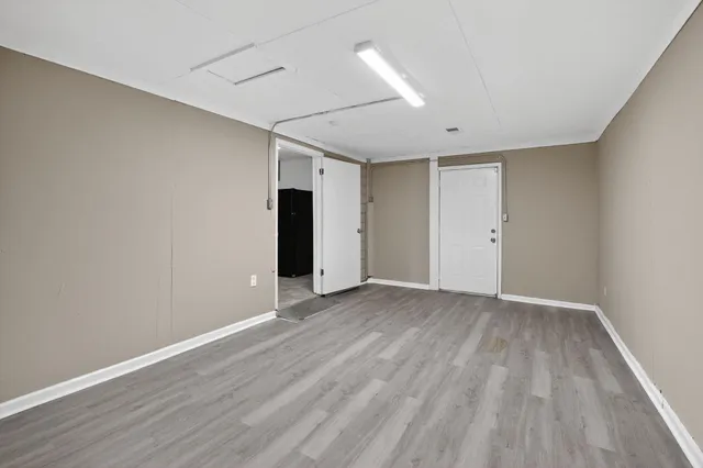 a view of an empty room with wooden floor