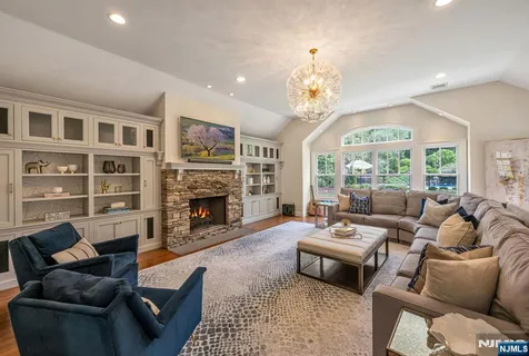a kitchen with stainless steel appliances granite countertop a table chairs stove a sink dishwasher a refrigerator and cabinets with wooden floor