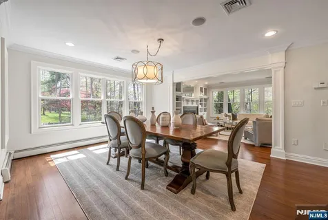 a view of a dining room with furniture a chandelier and wooden floor