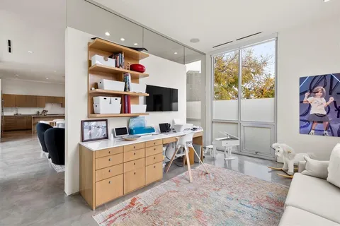 a living room with furniture a flat screen tv and a bookshelf