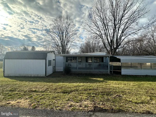 a view of a house with backyard and wooden fence