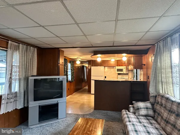 a living room with furniture a flat screen tv and a floor to ceiling window