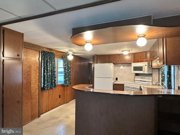 a kitchen with stainless steel appliances kitchen island granite countertop a refrigerator and a stove top oven