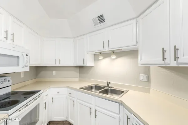 a view of kitchen with a sink dishwasher and wooden cabinets