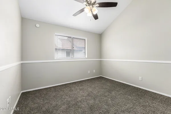 an empty room with closet and a chandelier fan