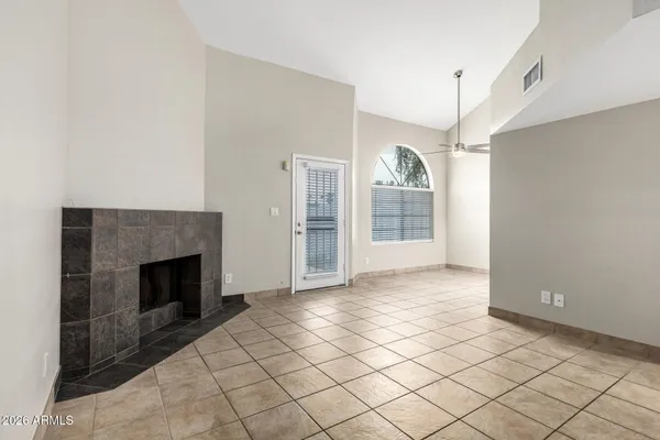 a view of an empty room with a fireplace and a window