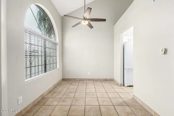a view of kitchen and empty room with windows
