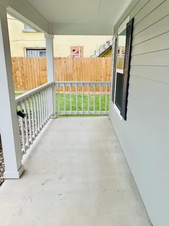 a view of a porch with wooden floor and fence