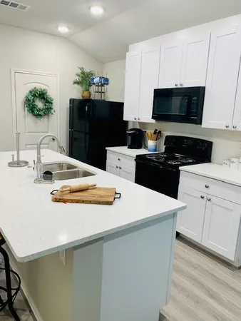 a kitchen with stainless steel appliances a stove microwave and sink