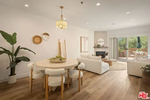 a view of a dining room with furniture large windows and wooden floor