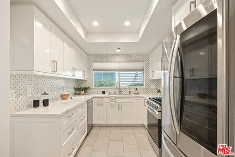 a kitchen with cabinets stainless steel appliances a sink and a window