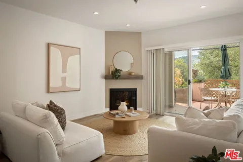 a living room with furniture a rug and white walls