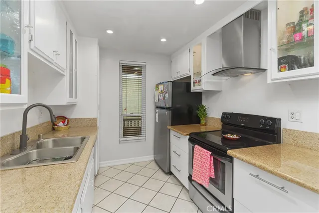 a kitchen with a sink dishwasher and a stove top oven with wooden floor