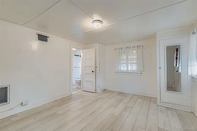 an empty room with cabinet and mirrors