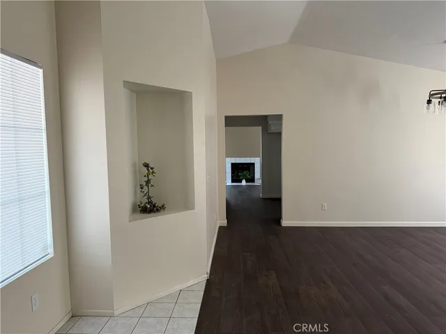 a view of a hallway with wooden floor and a bathroom