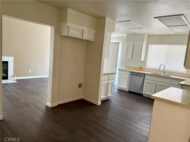 a view of a kitchen with wooden floor and electronic appliances